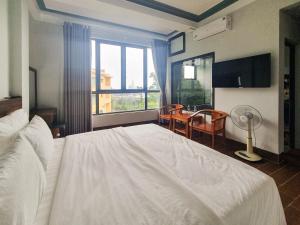 a bedroom with a large white bed and a window at TGlobal Hùng Trang Tam Đảo Hotel in Tam Ðảo +16 photos
