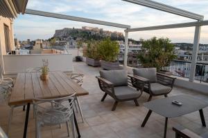 V&V Acropolis view apartment في أثينا: فناء على طاولة وكراسي على السطح