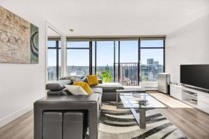 バンクーバーにあるCentral Luxury Apartment with Best City Views!のソファとテレビのあるリビングルーム