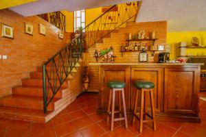 a kitchen with a bar with stools and a staircase at Quinta de São Francisco in Cinfães