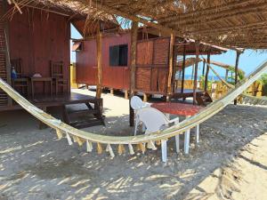 una hamaca frente a una cabaña en la playa en Cabañas Alta Mar en Guayabas