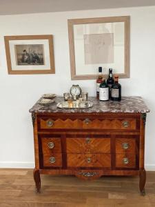 a wooden dresser with wine bottles on top of it at Péniche sur la Seine pour les Jeux Olympiques 2024 à Paris in Choisy-le-Roi