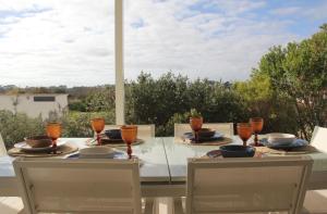 - une table avec deux chaises et une table avec des verres dans l'établissement Casa Menina do Mar in Carvalhal Beach, à Grândola
