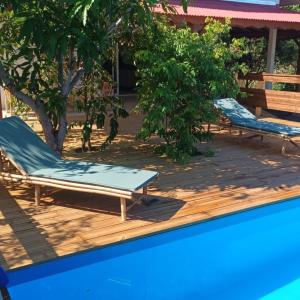 twee ligstoelen op een terras naast een zwembad bij VILLA CAJOU DESIRADE in Baie Mahault