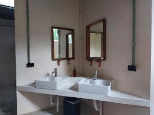 two sinks in a bathroom with two mirrors at Elmar hostal in Bacalar
