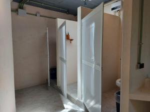 baño con 2 puertas abiertas y aseo en Elmar hostal en Bacalar