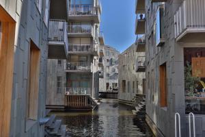 a canal between two buildings in a city at Bjørvika - Beside the sea & in the city, near Oslo Centralstation in Oslo