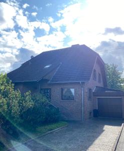 a brick house with a black roof and a garage at Ferienwohnungen Burgstraße 8 in Blankenheim