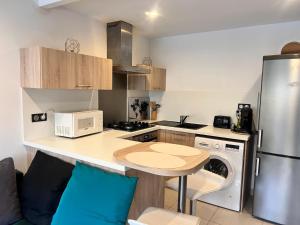 una cucina con bancone, forno a microonde e frigorifero di Bel appartement à 5 minutes de la plage a Cap d'Agde