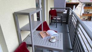 uma varanda com uma mesa com um livro e uma chávena de café em Ferienhaus2-Sölden em Sölden