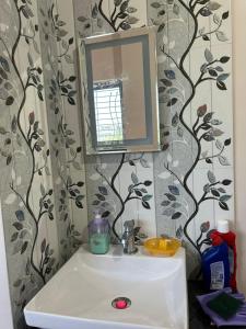 ein Badezimmer mit Waschbecken und Spiegel in der Unterkunft Self Check In 1BHK Home fully Equipped Kitchen in Nagpur + 27 Fotos