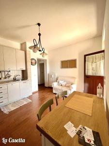 eine Küche und ein Wohnzimmer mit einem Holztisch mit Stühlen in der Unterkunft Masseria trulli pietra antica in Noci