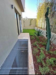 Un jardín con un cactus al lado de una casa. en Maison FK, en Casablanca