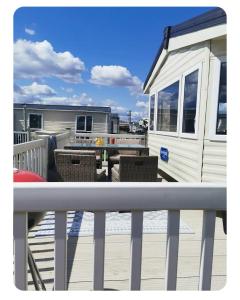 a white rv on a deck with a table and chairs at Alberta Holiday Park, HC13 in Seasalter