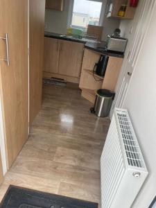 an empty kitchen with a staircase leading into a room at Alberta Holiday Park, HC13 in Seasalter