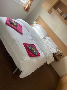 a white bed with two towels on top of it at Alberta Holiday Park, HC13 in Seasalter