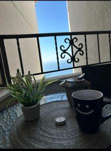 a table with a coffee cup and a potted plant at Apartment with three Rooms in Prijevor