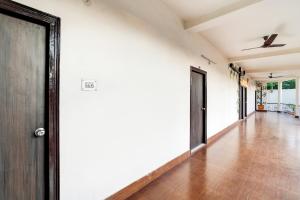 un pasillo vacío con paredes blancas y una puerta en Super Capital O Gulmohar Marriage Garden, en Dhanbād