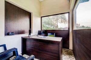 una oficina con escritorio de madera y ventana en Super Capital O Gulmohar Marriage Garden, en Dhanbād