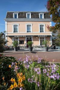 グランビルにあるAu Bout Du Quaiの花の咲くピンクの建物