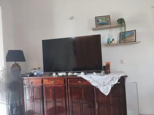 TV de pantalla plana en la parte superior de un armario de madera en Appartement d'une chambre avec terrasse amenagee et wifi a Morne a l'Eau a 5 km de la plage en Morne-à-lʼEau