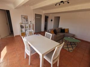 uma mesa branca e cadeiras numa sala de estar em Appartement avec terrasse Classé em Port-la-Nouvelle