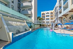 a swimming pool in the middle of a building at Lefkoniko Residence Beach & Bay in Rethymno