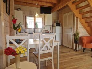 a kitchen with a white table and chairs in a room at Domki U Wojtka w Niechorzu in Niechorze