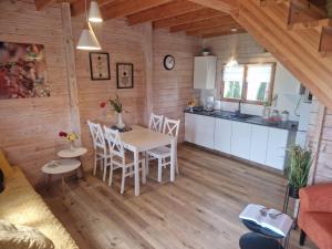 a kitchen and dining room with a table and chairs at Domki U Wojtka w Niechorzu in Niechorze +12 photos