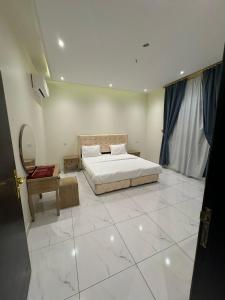 a bedroom with a bed and a tiled floor at أجنحة دارنـــــا للـــشقق الــمــفــروشــة in Abha