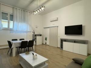 salon ze stołem i telewizorem z płaskim ekranem w obiekcie Sweet home-Casa Di Bari w mieście Turi