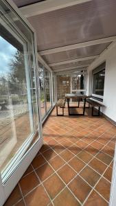 eine abgeschirmte Veranda mit einem Picknicktisch und Fenstern in der Unterkunft Villa Sonnenblick 13 Minuten zum #Playmobil #Funpark in Großhabersdorf