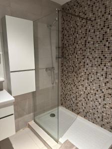 een douche met een glazen deur in de badkamer bij La Cascade 1 in Oran