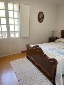 1 dormitorio con 1 cama y reloj en la pared en Casa do Cuco, Ribeira Sacra, en Ourense