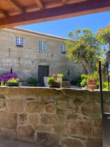 奧倫塞的住宿－Casa do Cuco, Ribeira Sacra，墙上有盆栽植物的石头建筑
