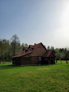 a large wooden house in a field of grass at Agroturystyka u Doroty in Rajgród