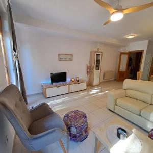 sala de estar con sofá y TV en Casa Lliri con piscina en Massalfassar VALENCIA en Masalfasar