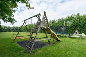 a playground with a slide and a swing at Luxe safaritent op Landgoed de Leijen in Hensbroek