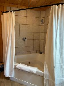 a bath tub with a shower curtain in a bathroom at Classy Bear Cabin in Gatlinburg