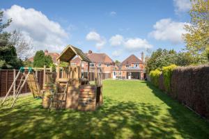 a yard with a playground in front of a house at Lythwood House in Gloucester