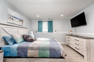 a bedroom with a bed and a flat screen tv at Neptune By The Water in Annapolis