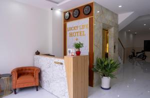 un vestíbulo con un hotel con una silla y relojes en lucky life hotel, en Ấp Nhât (2)