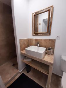 La salle de bains est pourvue d'un lavabo et d'un miroir. dans l'établissement Maison au pied de la st victoire avec piscine, à Pourrières