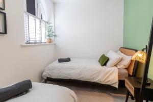 two beds in a small room with a window at Stunning two bedroom in city centre in Southampton