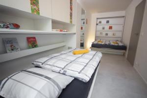 two beds in a room with white walls and shelves at Apartmán víla Amálka in Janov nad Nisou