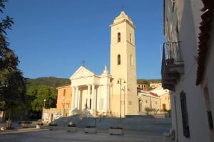 a large white building with a clock tower at B&B La Torre in Loceri +49 photos