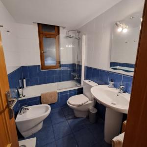 baño azul y blanco con aseo y lavamanos en Casa Lliri con piscina en Massalfassar VALENCIA, en Masalfasar