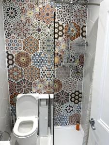 a bathroom with a toilet and a tiled wall at A Cosy Flat With A Dales View in Ingleton +18 photos