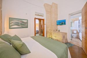 a bedroom with a large bed and a bathroom at Palazzo Personè Dimora Storica in Lecce
