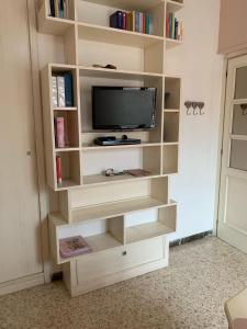 TV en una estantería de libros en una habitación en GRAZIOSO MONOLOCALE OSTIA ROMA, en Lido di Ostia